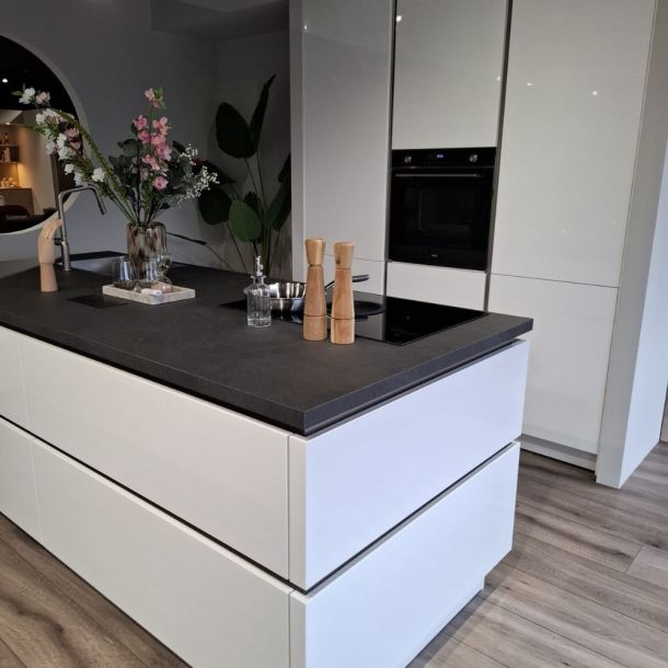 Witte designkeuken met kookeiland, inductiekookplaat met afzuiging en inbouwapparatuur – demomodel
