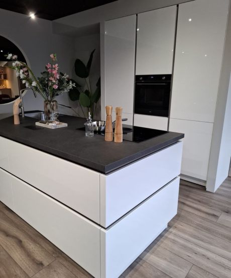 Witte designkeuken met kookeiland, inductiekookplaat met afzuiging en inbouwapparatuur – demomodel