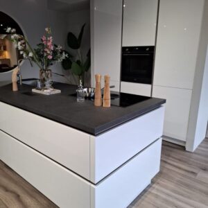Witte designkeuken met kookeiland, inductiekookplaat met afzuiging en inbouwapparatuur – demomodel